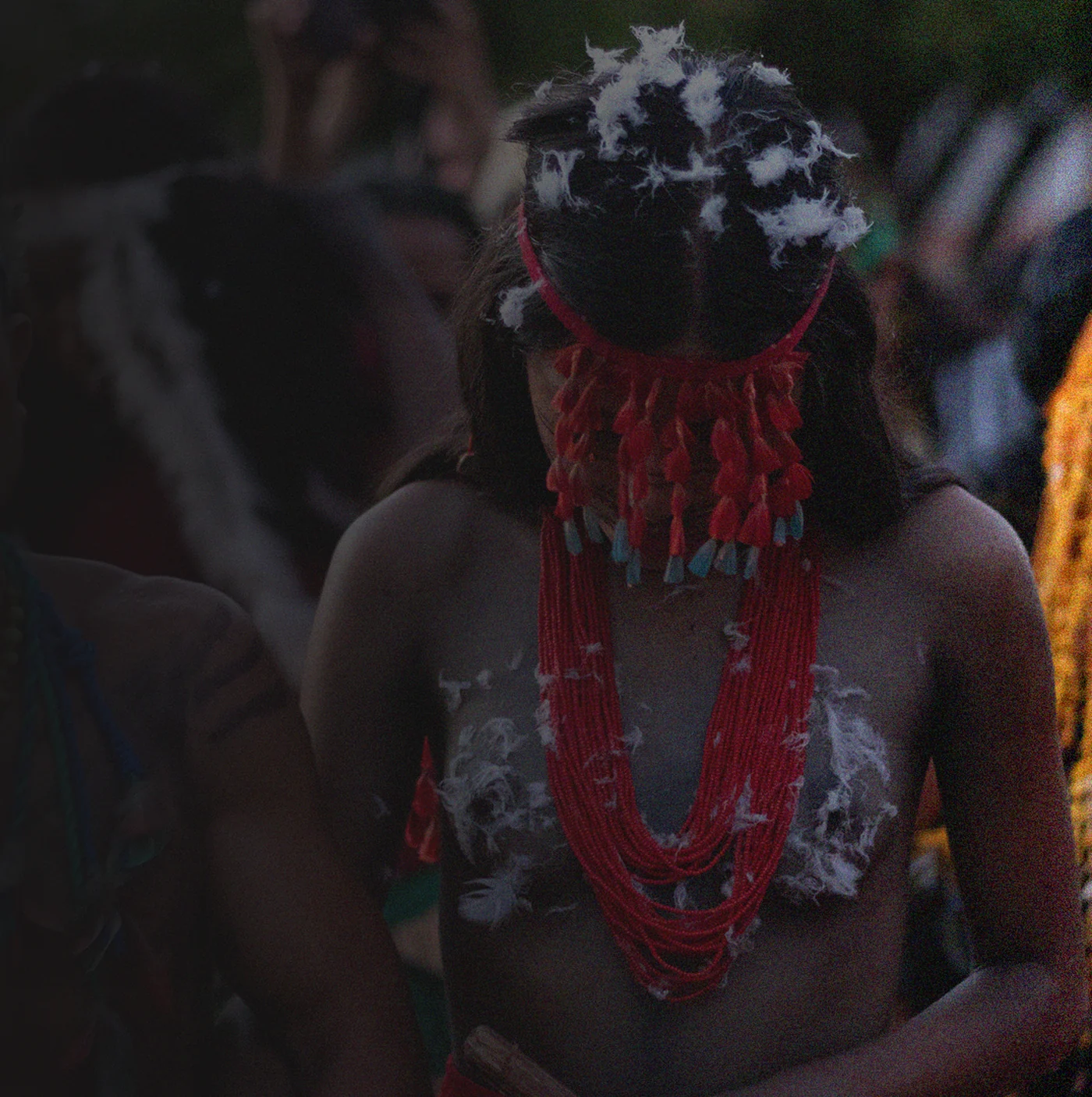 Young Indigenous person with a headdress and red necklaces