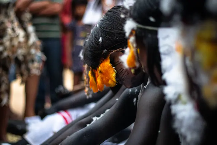 Meninas moças na Festa do Moqueado, com penas e adornos no cabelo.