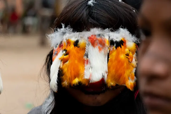 Adorno de penas sobre os olhos de uma menina moça, na Festa do Moqueado.