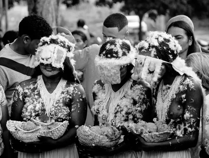 Meninas moças com penugem branca e cuias nas mãos, na Festa do Moqueado.