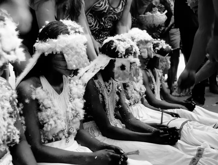 Meninas moças sentadas lado a lado na Festa do Moqueado.