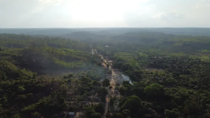 A aldeia vista do alto, cercada pela floresta.